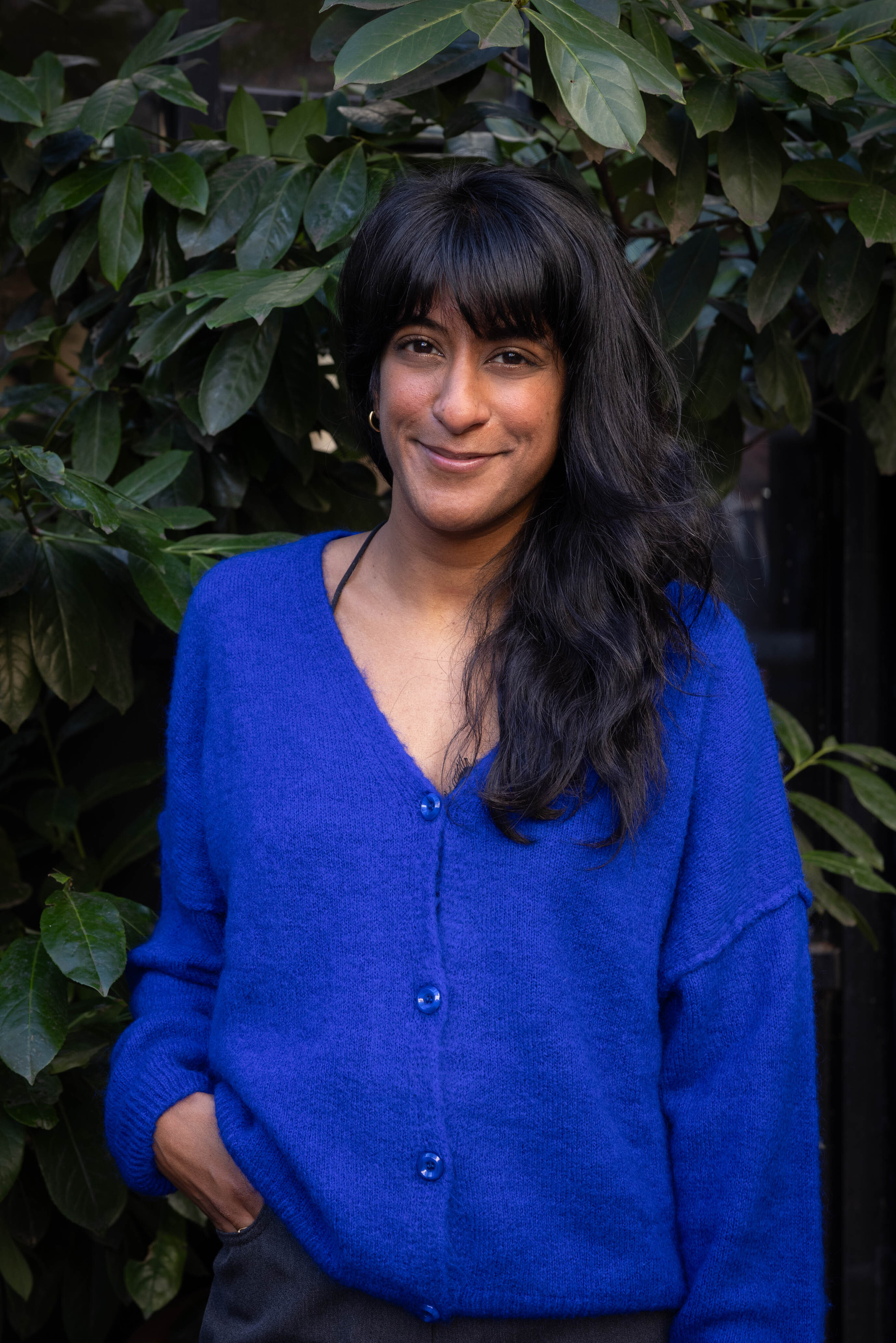 Portrait einer Frau mit schwarzen Haaren und blauer Bluse