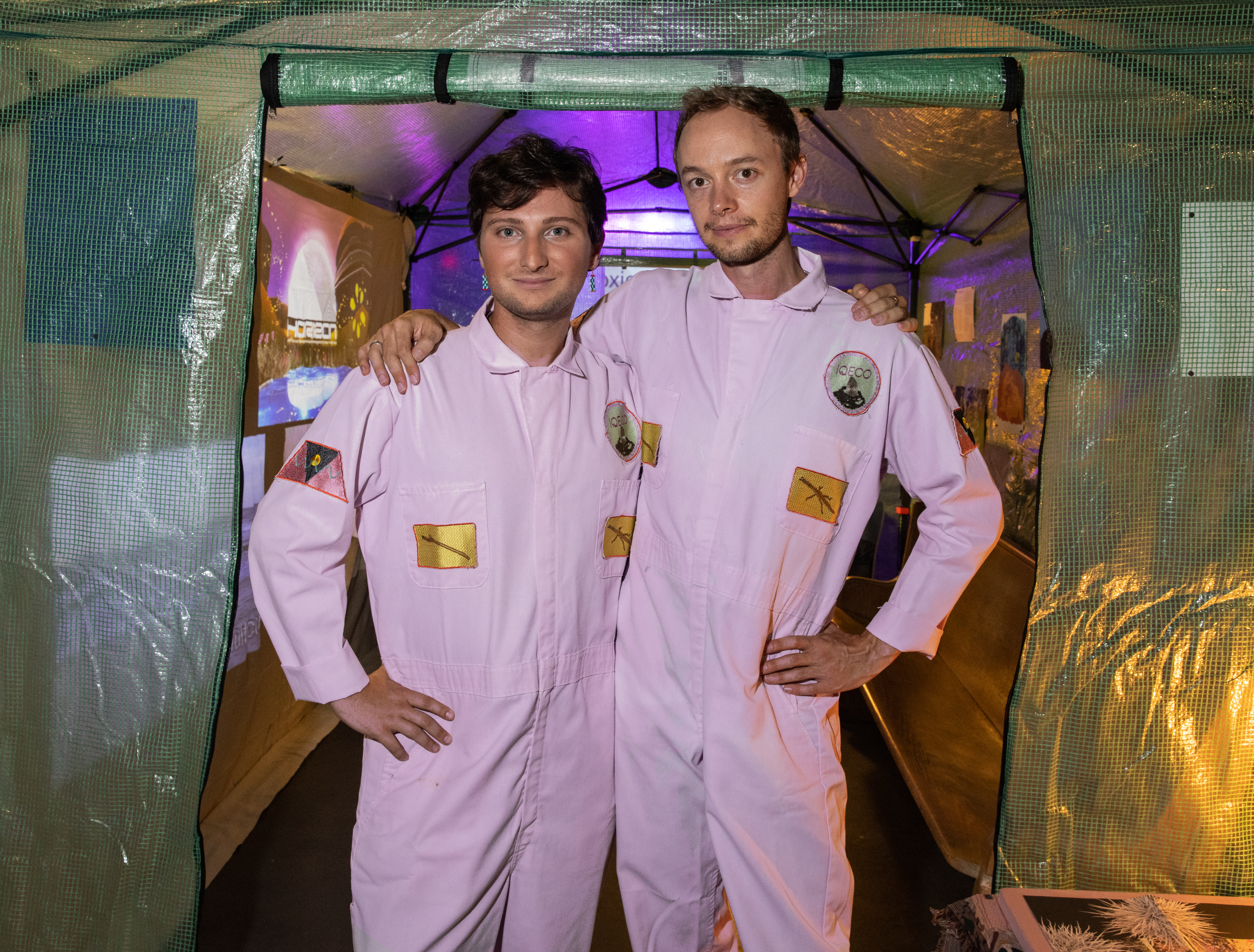 zwei Männer in rosa Jumper vor einem Zelt