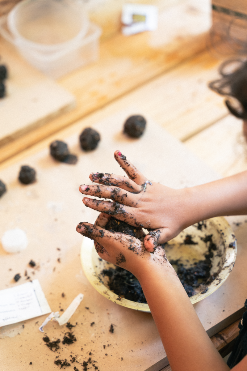 Kinderhände die aus Erde kleine Kugeln formen