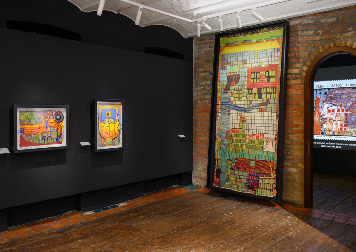 Bunte Bilder und eine Tapisserie auf schwarzen Wänden