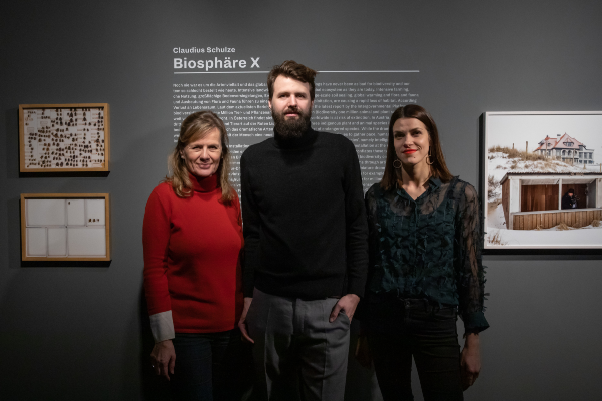 Die Direktorin, der Künstler und die Kuratorin posieren für ein Foto