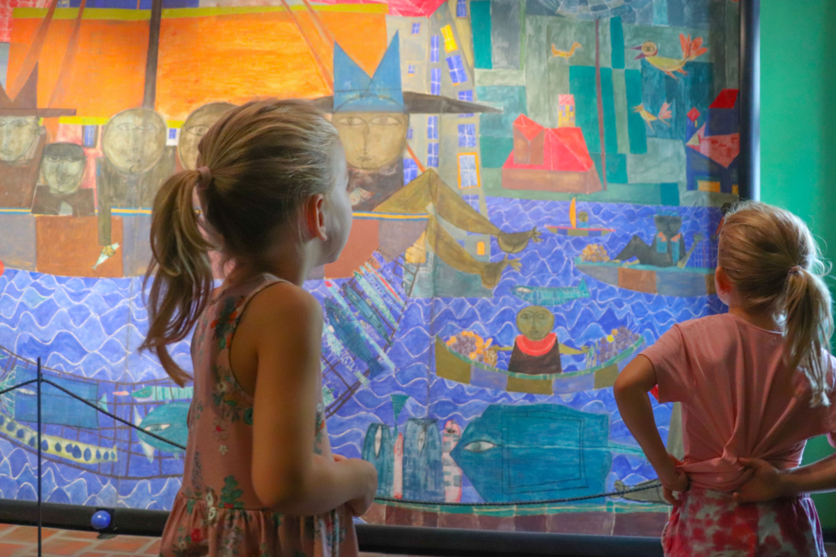 Zwei Kinder mit blonden Haaren schauen auf ein Bild