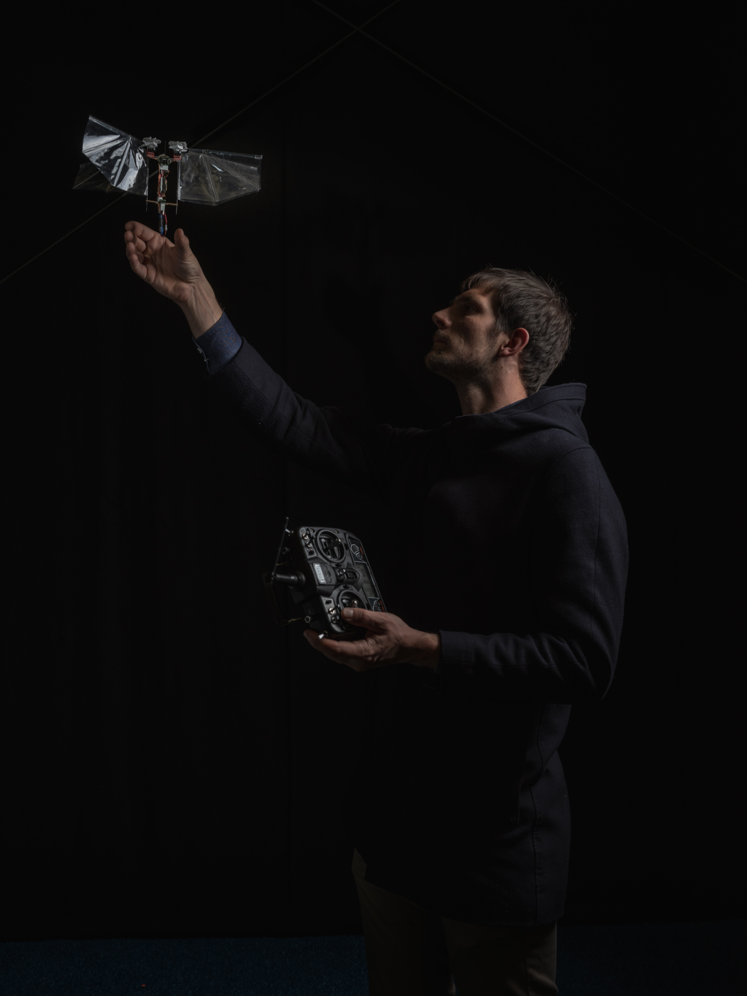 Ein Mensch lässt eine autonomische bionische Drohne im dunklen fliegen