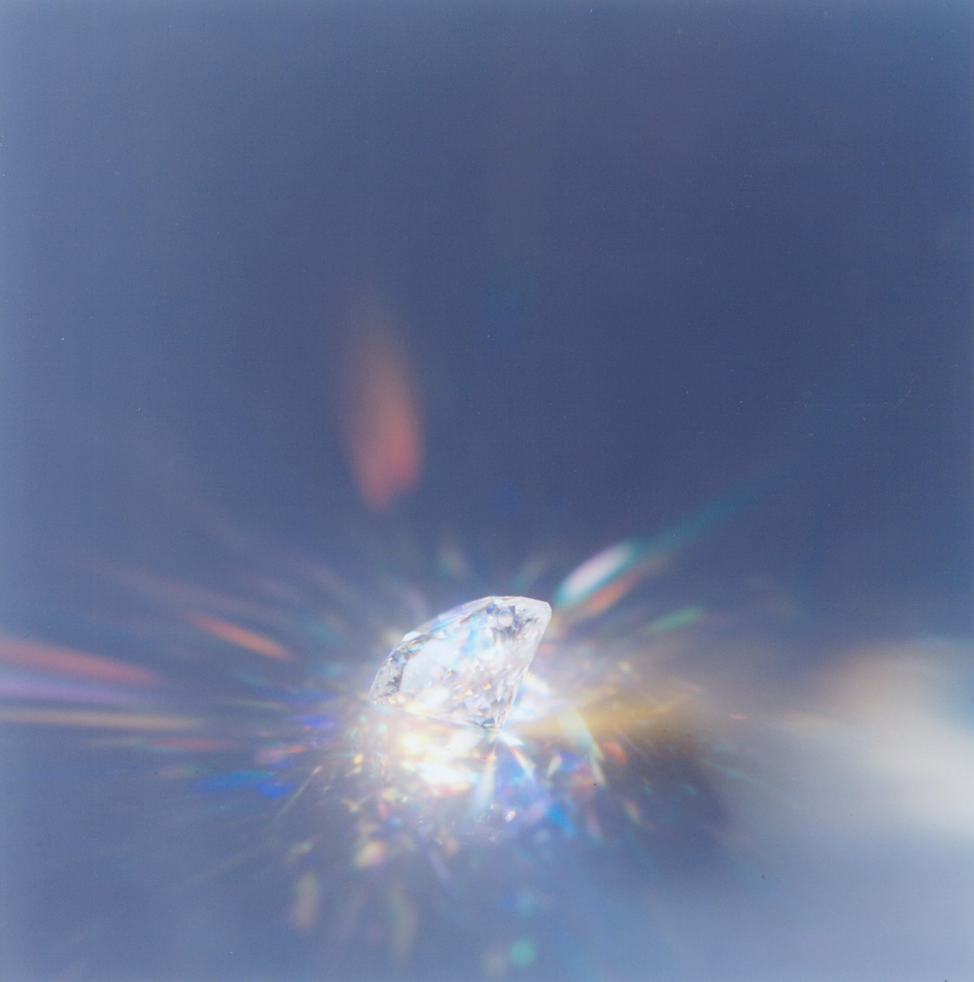 Diamant reflektiert Licht vor grauem Hintergrund